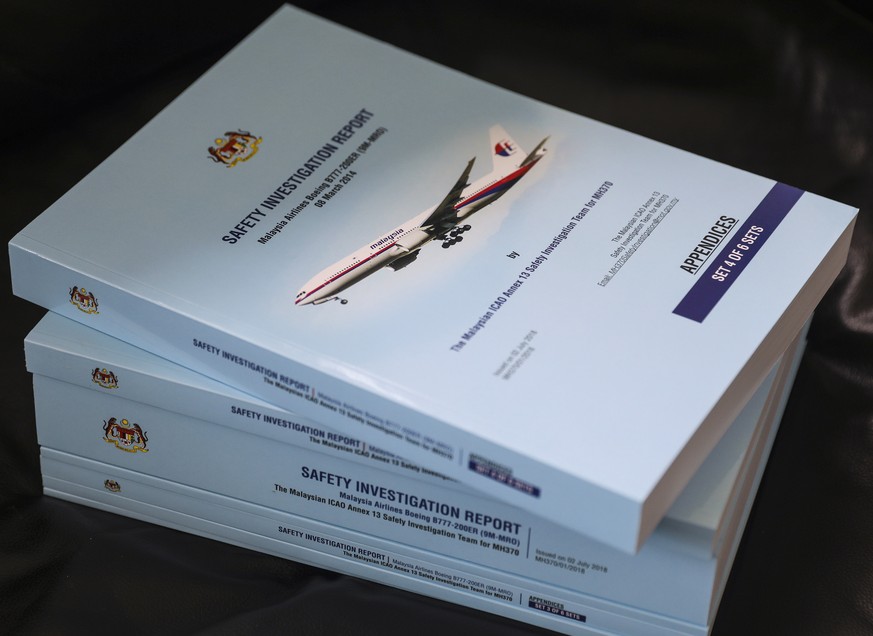 epa06918633 MH370 safety investigation reports are piled during a media briefing at the Ministry of Transport headquarters in Putrajaya, Malaysia, 30 July 2018. Malaysia has released the final report  ...
