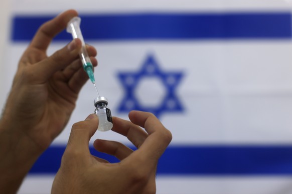 FILE - In this Jan. 7, 2021 file photo, an Israeli military paramedic prepares a Pfizer COVID-19 vaccine, to be administered to elderly people at a medical center in Ashdod, southern Israel. On Friday ...