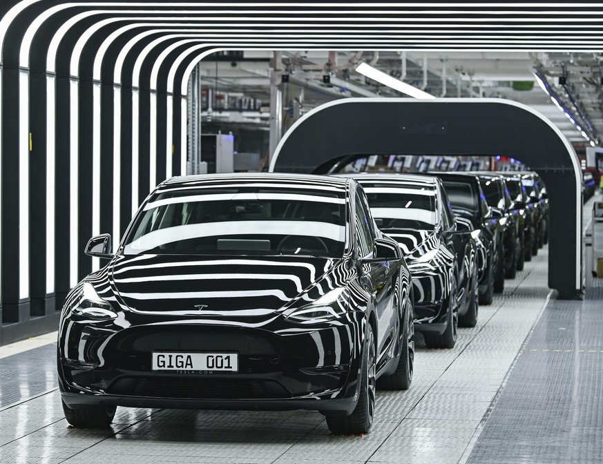 Model Y electric vehicles stand on a conveyor belt at the opening of the Tesla factory in Berlin Brandenburg in Gruenheide, Germany, Tuesday, March 22, 2022. The first European factory in Gruenheide,  ...