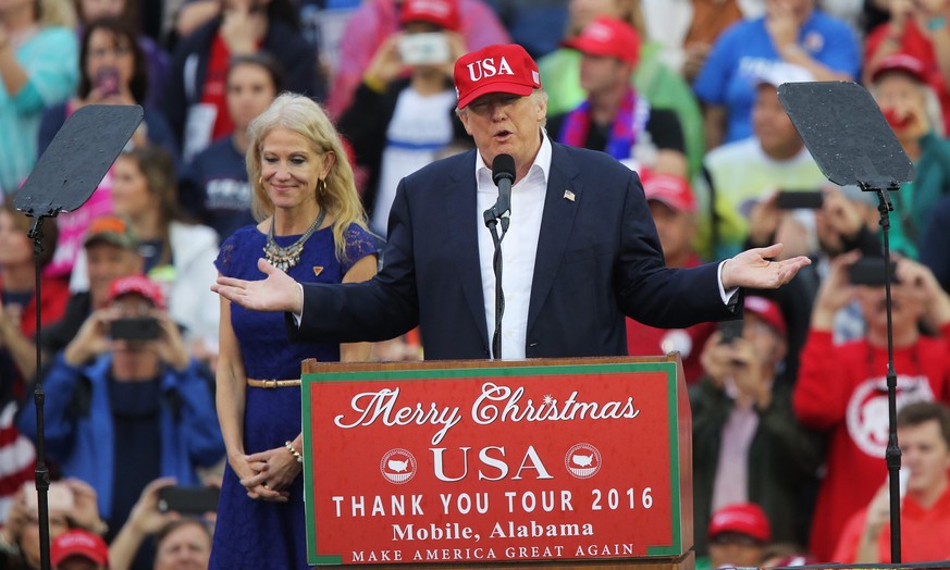 epa05680291 Campaign manager Kellyanne Conway (L) stands next to US President-elect Donald Trump speaking to the crowd at Ladd-Peebles Stadium in Mobile, Alabama, USA, 17 December 2016. The stop is a  ...