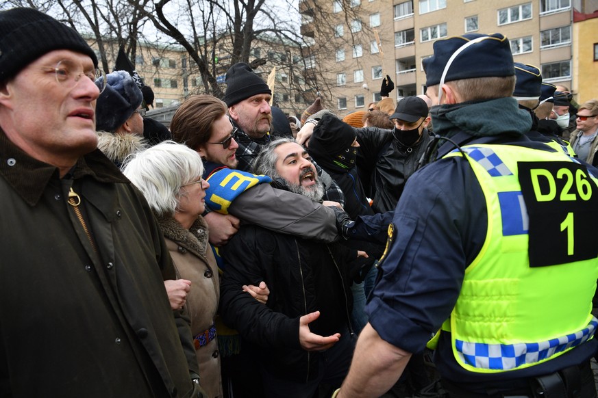 epa09056848 People take part in an anti-lockdown protests in Stockholm, Sweden, 06 March 2021. The protests against lockdown and ban on large gathering were disbanded by police due to lack of permit f ...