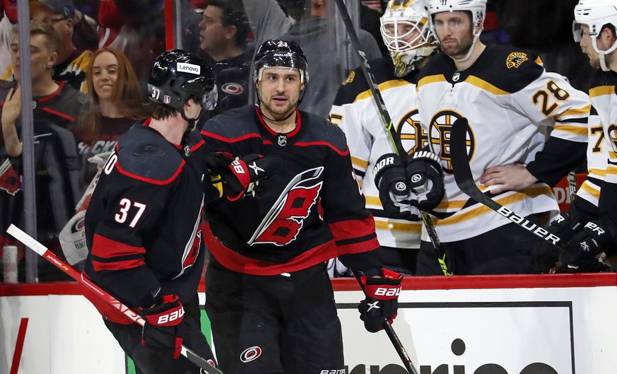 Carolina Hurricanes&#039; Nino Niederreiter, right front, is congratulated on his empty-net goal by Andrei Svechnikov (37) as the skate by the Boston Bruins&#039; bench during the third period of Game ...
