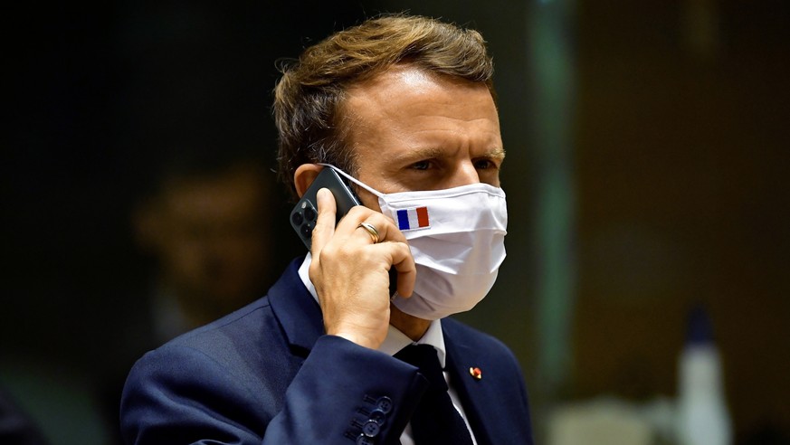 FILE - In this Monday, July 20, 2020 file photo, French President Emmanuel Macron speaks on his mobile phone during a round table meeting at an EU summit in Brussels. French newspaper Le Monde is repo ...