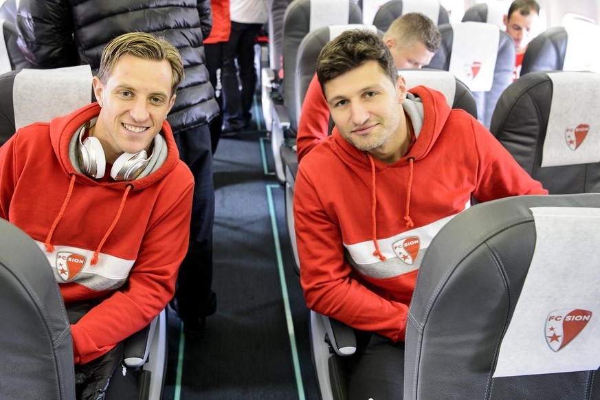 FC Sion&#039;s soccer players Reto Ziegler, left, and Veroljub Salatic, right, wait in their seat on the plane after boarding at the Geneva airport, in Geneva, Switzerland, Tuesday, November 24, 2015. ...