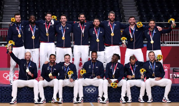 epa09404200 French team players pose with their gold medals on the podium after winning the Men&#039;s Gold medal match between France and Denmark, at the Handball events of the Tokyo 2020 Olympic Gam ...