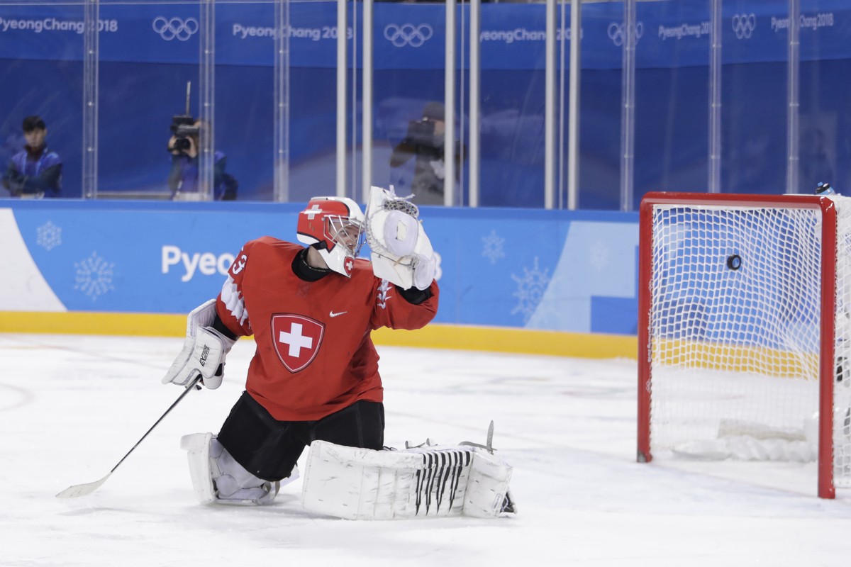 Switzerland goalkeeper Leonardo Genoni watches as a shot by Wojtek Wolski (8), of Canada, enters his net for a goal during the second period of a preliminary round men's hockey game at the 2018 W ...