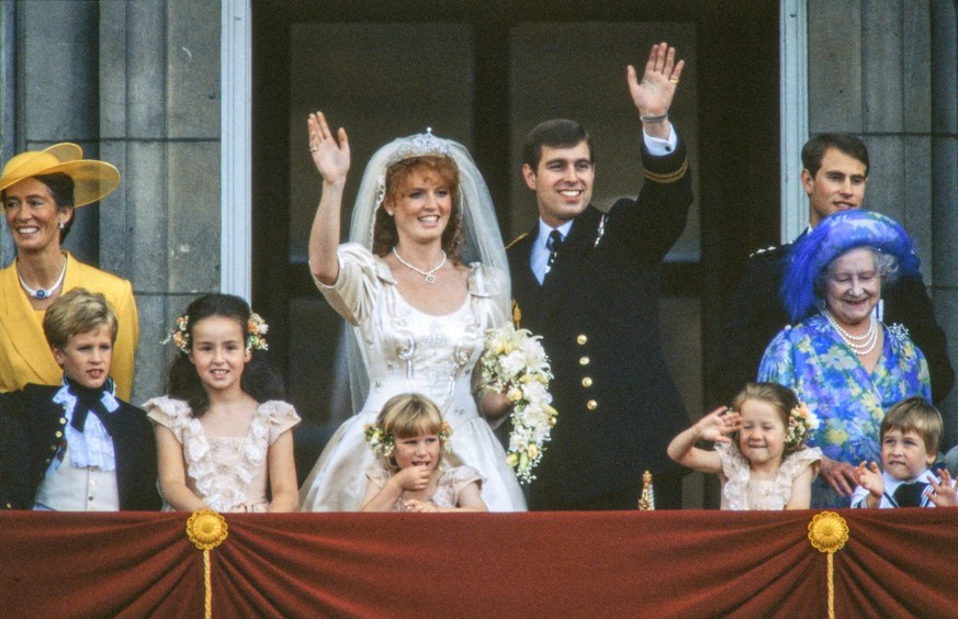 View of just-married couple Sarah, Duchess of York (center left), and Prince Andrew, Duke of York (center right), as they wave from the balcony of Buckingham Palace, London, England, July 23, 1986. Am ...