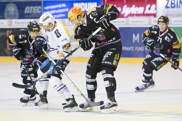 Fribourgs Marc Abplanalp, links, Ambris Stuermer Oliver Kamber, Mitte-links, und Fribourgs Topscorer, Julien Sprunger, Mitte-rechts, kaempfen um den Puck, beim Eishockey Meisterschaftsspiel der Nation ...