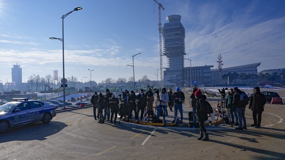 Journalists wait outside the VIP terminal at the Nikola Tesla airport in Belgrade, Serbia, Monday, Jan. 17, 2022. Novak Djokovic is expected to arrive in the Serbian capital following his deportation  ...