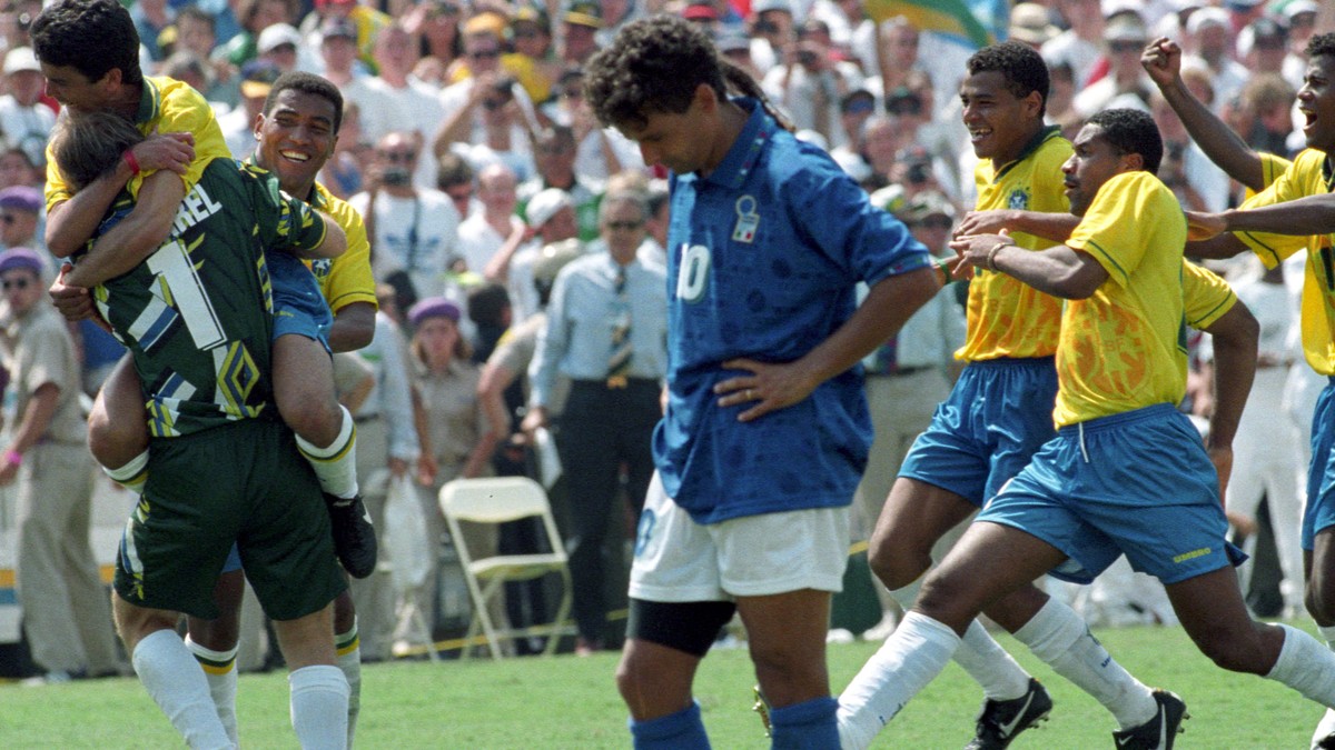 Brazilian striker Bebeto leaps into the arms of goalkeeper Claudio Taffarel (L) as Italy's Roberto Baggio (C) stares at the ground after missing the penalty kick which cost his team the World Cup ...