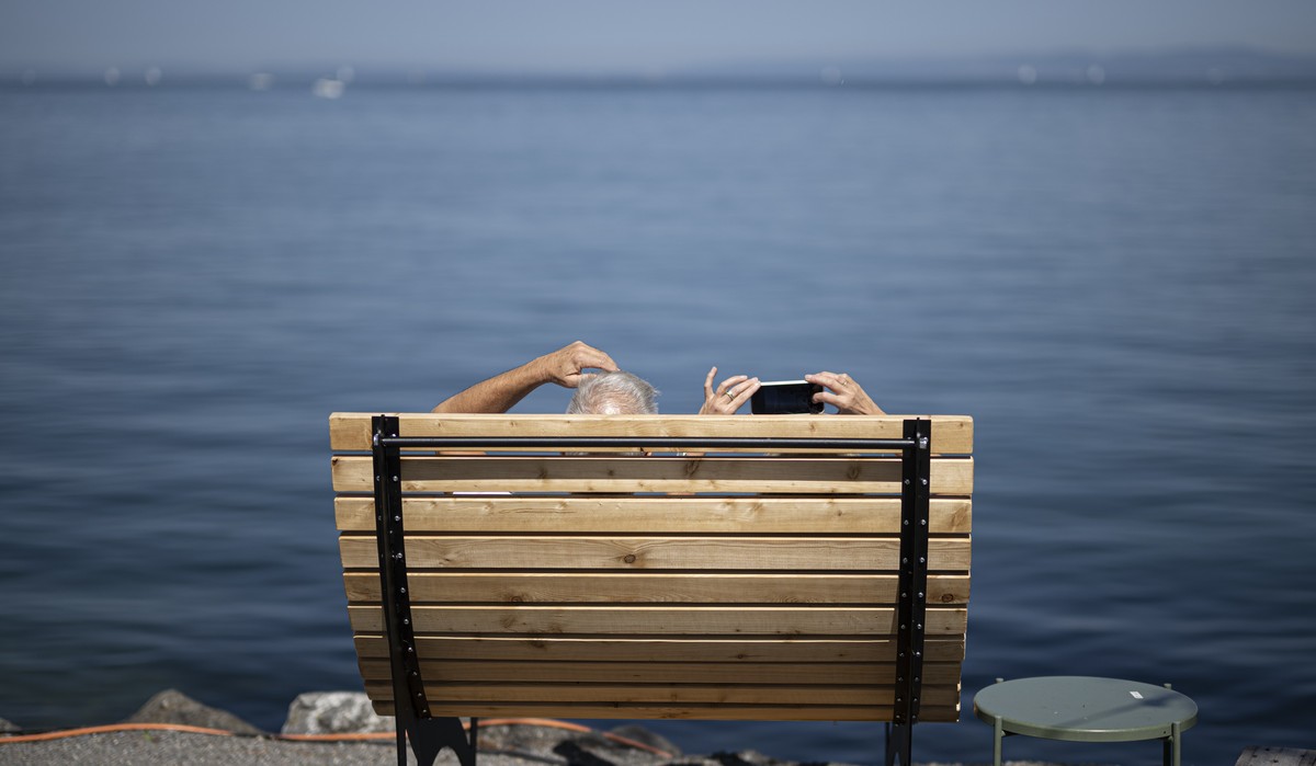 Eine Frau macht ein Foto, am Freitag, 18. August 2023, am Bodensee in Rorschach. Die kommenden Tage sollen grossen Teile der Schweiz eine Hitzewelle bringen. (KEYSTONE/Gian Ehrenzeller)