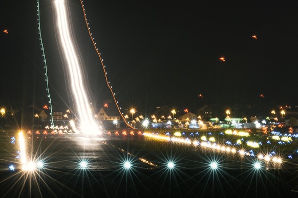 ZUM FLUGVERKEHR AM FLUGHAFEN ZUERICH STELLEN WIR IHNEN HEUTE, MITTWOCH, 23. AUGUST 2017, FOLGENDE NEUE NACHTAUFNAHMEN ZUR VERFUEGUNG --- The landing lights of an airplane form light trails, pictured a ...