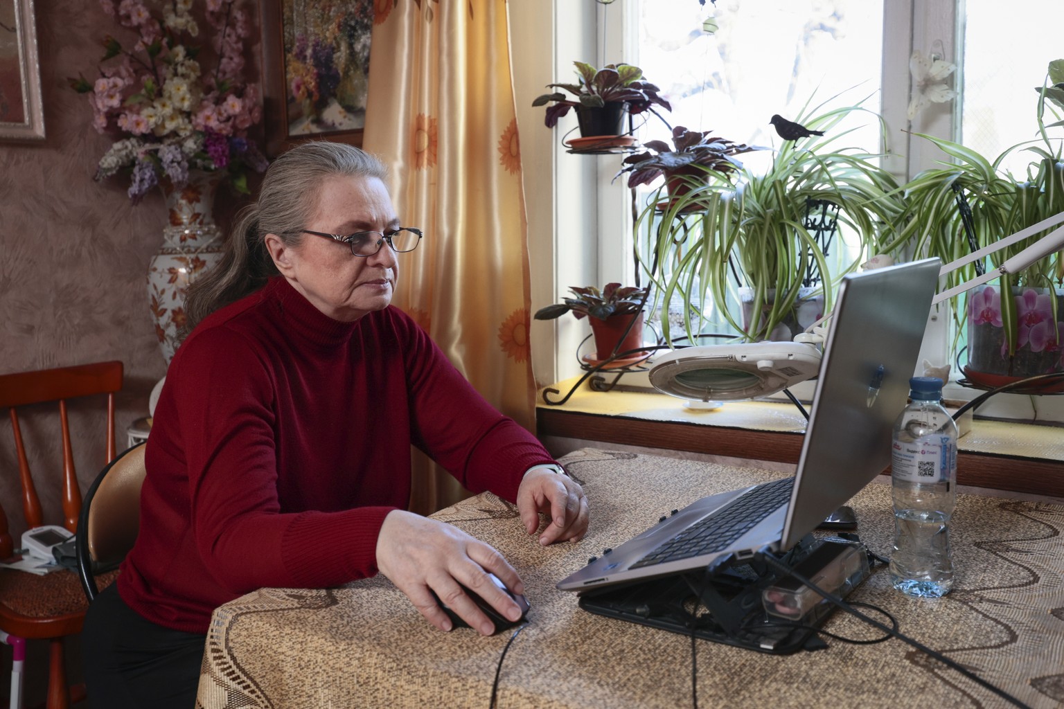 A woman uses her laptop for electronic voting during a presidential election in the village of Petrovo-Dalneye, outside Moscow, Russia, Friday, March 15, 2024. Voters in Russia are heading to the poll ...