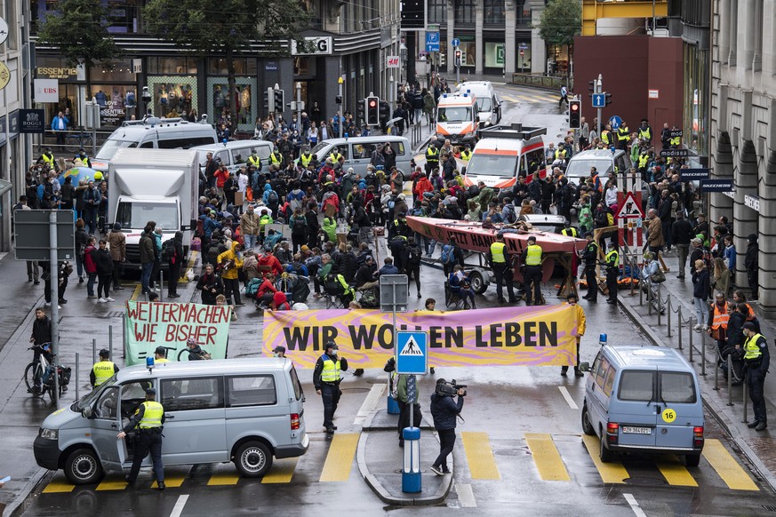 Menschen der Klimaorganisation &quot;Extinction Rebellion&quot; blockieren die Strasse in der Zuercher Innenstadt, aufgenommen am Montag, 4. Oktober 2021 in Zuerich. (KEYSTONE/Ennio Leanza)