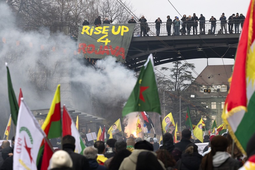 Demonstranten gehen ueber die Kornhausbruecke und halten Banner und Fahnen waehrend einer nationalen Demonstration "Auf die Strassen fuer Rojava!" am Samstag, 31. Januar 2026, in Bern. (KEYS ...