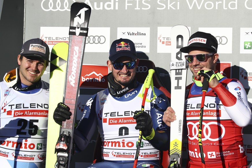 Italy&#039;s Dominik Paris, center, sits with Switzerland&#039;s Urs Kryenbuehl, left, and Switzerland&#039;s Beat Feuz at the finish area of an alpine ski, men&#039;s World Cup downhill, in Bormio, I ...