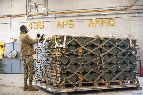 In this image provided by the U.S. Air Force, Airmen and civilians from the 436th Aerial Port Squadron palletize ammunition, weapons and other equipment bound for Ukraine during a foreign military sal ...