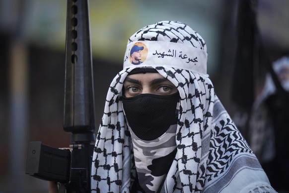 Masked Palestinian militants march during a rally to commemorate two of their fellows in the West Bank refugee camp of Balata, Saturday, March 4, 2023. Ahmed Abu Junid and Amer Abu Zeitoun were member ...