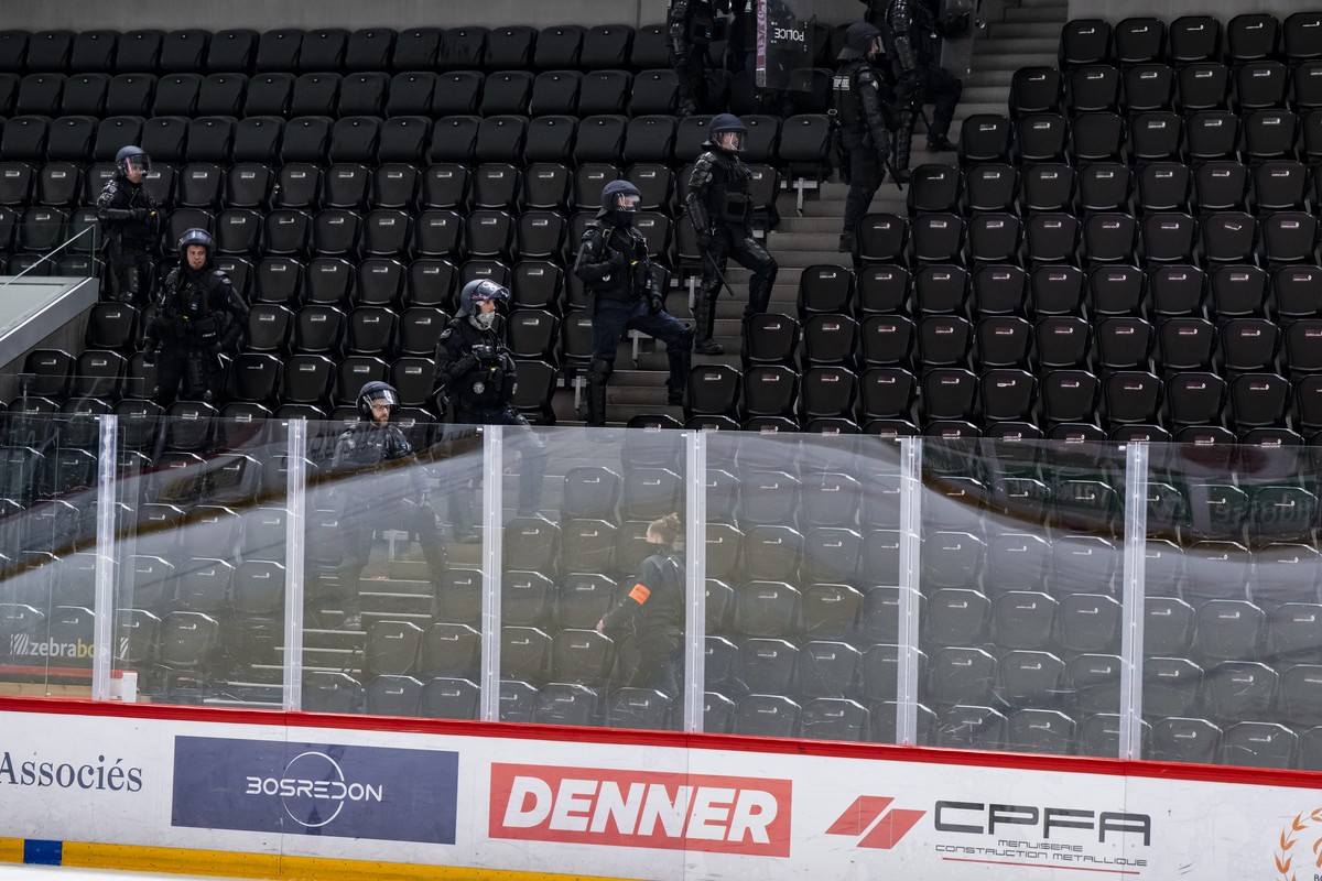 Des policiers anti-emeute interviennent dans la patinoire lors de l'Acte 4 des quarts de finale des play-off du championnat suisse de hockey sur glace de National League entre Lausanne HC, LHC, e ...