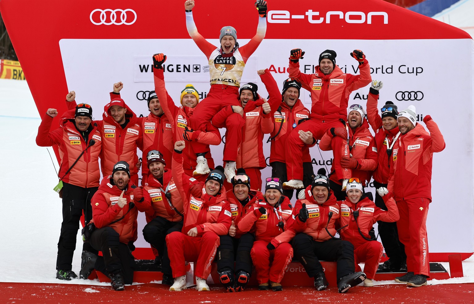 Second placed Marco Odermatt of Switzerland, top center, and fifth placed Beat Feuz of Switzerland, top right, celebrate with the team members on the podium after the men&#039;s downhill race at the A ...