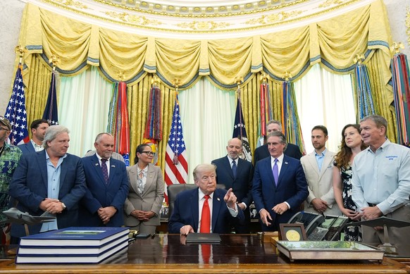 President Donald Trump points to a reporter during an event to sign a proclamation about the fishing industry, in the Oval Office of the White House, Thursday, June 11, 2026, in Washington. (AP Photo/ ...