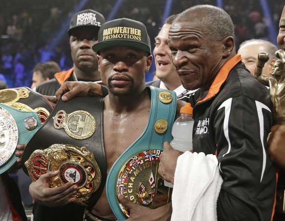 Floyd Mayweather Jr., left, poses with his champion&#039;s belts and his father, head trainer Floyd Mayweather Sr., after his victory over Manny Pacquiao, from the Philippines, in their welterweight t ...