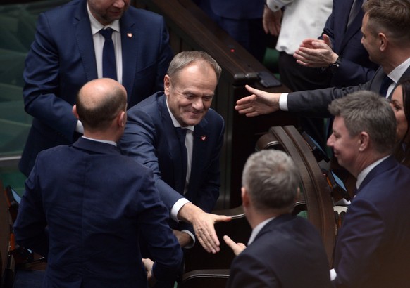epa11025402 New Polish Prime Minister Donald Tusk (C) is congratulated in the Sejm, the lower house of parliament, after his government faced a confidence vote in Warsaw, Poland on December 12, 2023.  The...