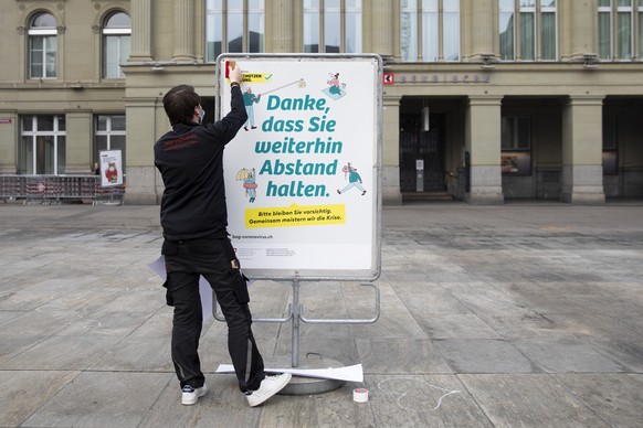 Ein neues weisses BAG-Plakat mit der Verhaltensregel &quot;Danke, dass Sie weitherin Abstand halten&quot;, &quot;Merci de continuer a garder vos distances&quot; im Umgang mit dem Coronavirus wird auf  ...