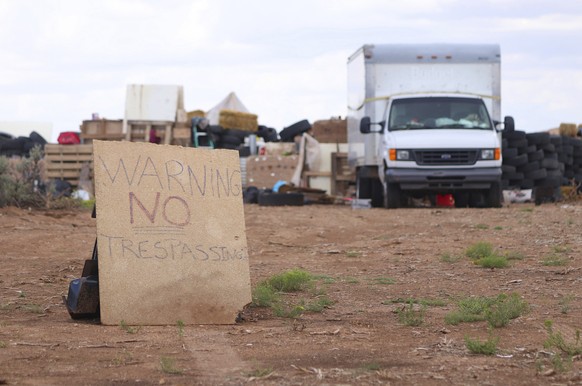 This Aug. 5, 2018 photo shows a &quot;no trespassing&quot; sign outside the location where people camped near Amalia, N.M. Three women believed to be the mothers of 11 children found hungry and living ...