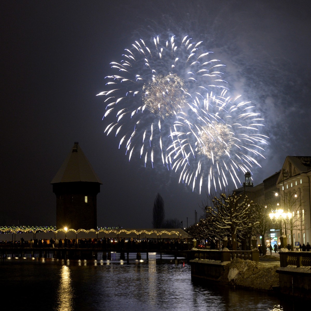 Mit einem Feuerwerk neben der Kappelerbruecke wird in der Stadt Luzern das neue Jahr begruesst am Freitag, 1. Januar 2015. (KEYSTONE/Urs Flueeler)

New year fireworks explode over the famous Chapel  ...