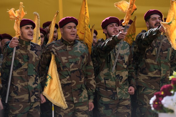 Hezbollah fighters shout slogans during the funeral procession of Hezbollah's chief of staff, Haytham Tabtabai and other fighters who were in Sunday's Israeli airstrike, in the southern subu ...