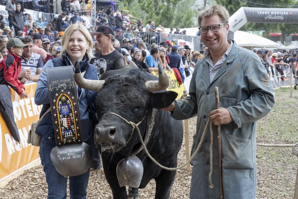 The Herens cow &quot;Tigresse&quot; of former Swiss politician and President of the Swiss People&#039;s Party (SVP/UDC) Toni Brunner, right, and with girlfriend Esther Friedli, left, pose after they w ...