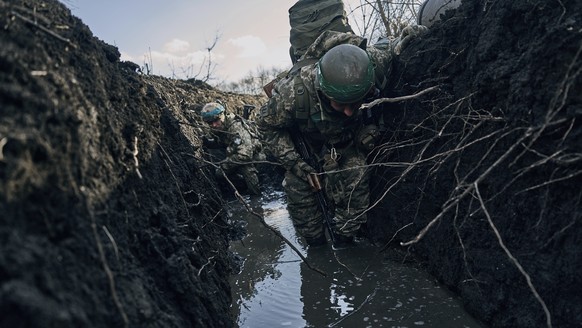 Ukrainian soldiers in a trench under Russian shelling on the frontline close to Bakhmut, Donetsk region, Ukraine, Sunday, March 5, 2023. (AP Photo/Libkos)