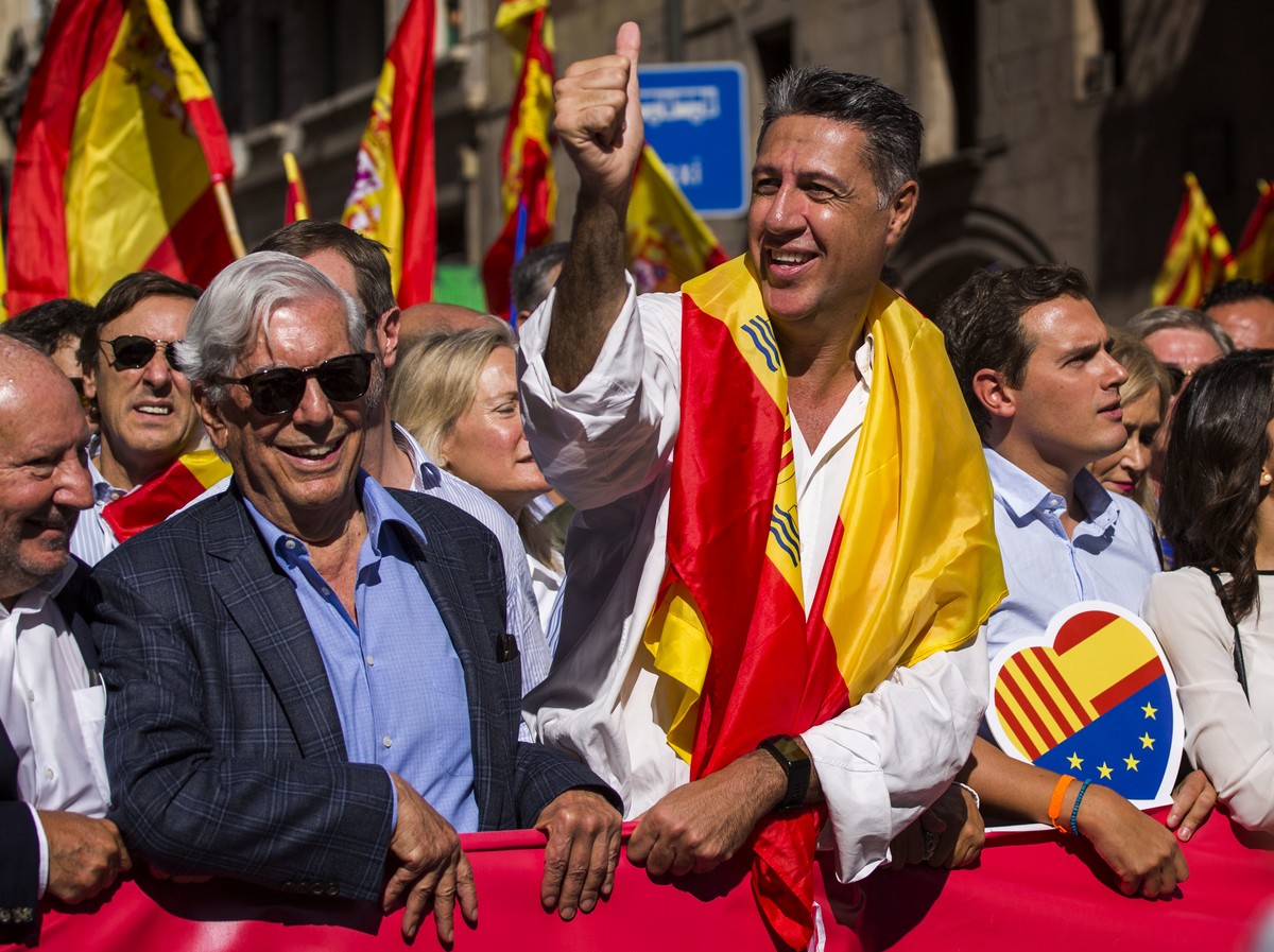Nobel laureate Mario Vargas Llosa, center left, stands next to Popular Party leader in Catalonia Xavier Garcia Albiol, right, as they lead a march to protest the Catalan government's push for sec ...