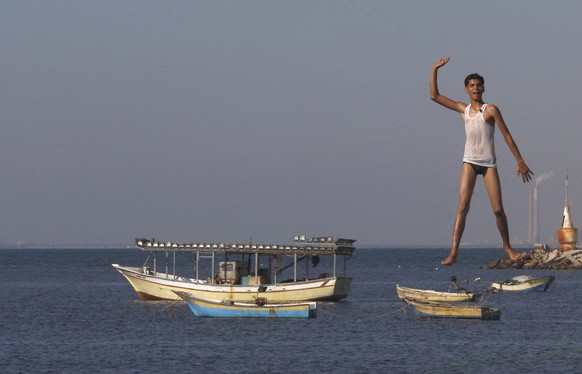 A Palestinian youth jumps into the Mediterranean sea on the beach at the port of Gaza City, Gaza, Monday, Aug. 27, 2012. (AP photo/Hatem Moussa)