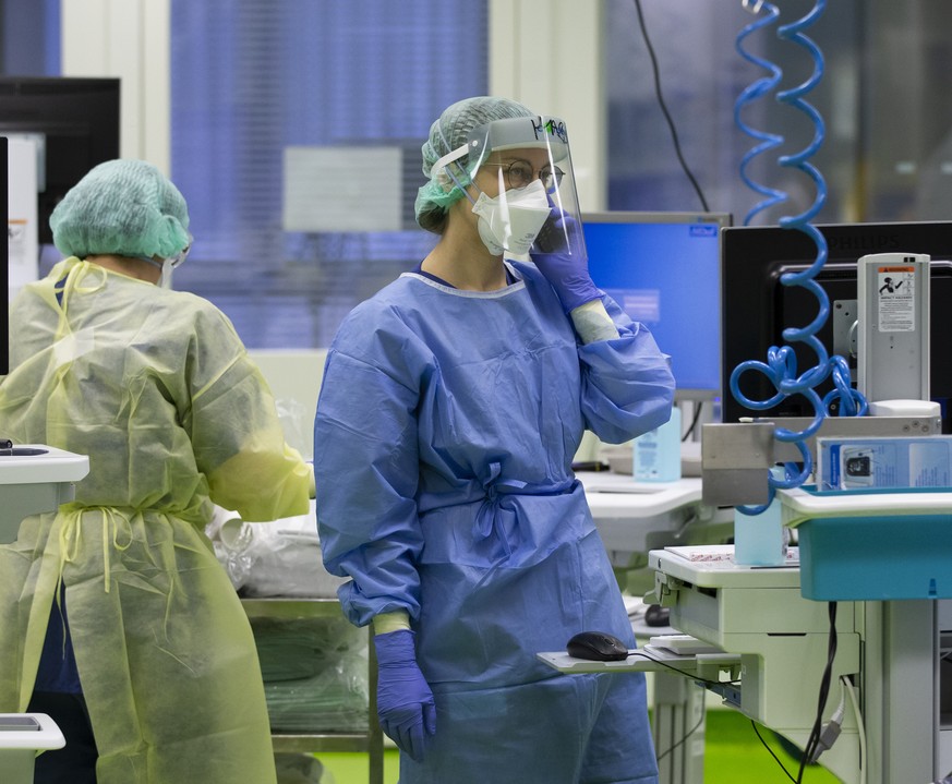 Aerzte und Pflegende kuemmern sich um Covid-Patienten in einer Intensivstation im Universitaetsspital Basel, am Montag, 28. Dezember 2020, in Basel. (KEYSTONE/Peter Klaunzer)