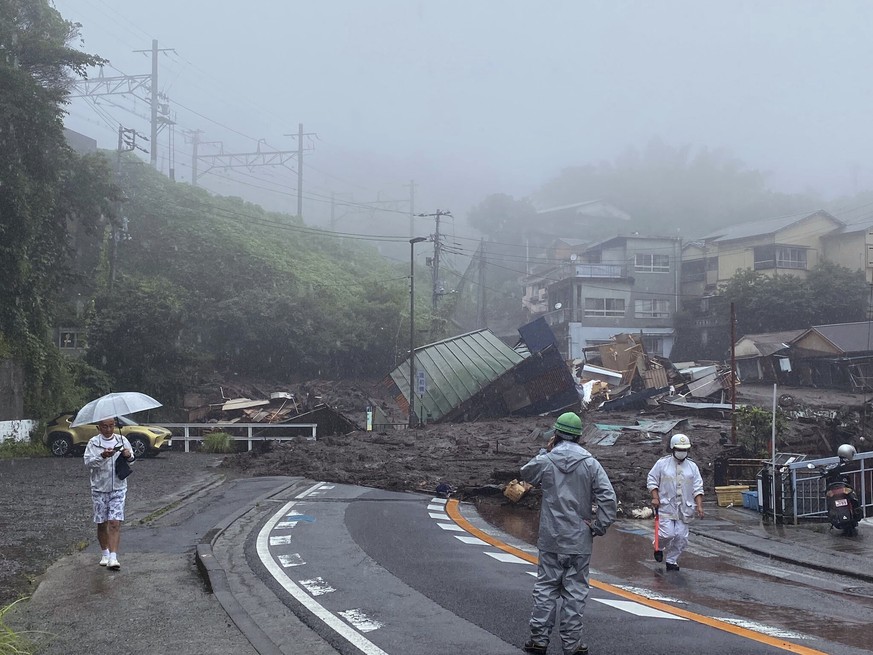 In this photo taken and provided by Satoru Watanabe, a road is covered by mud and debris following heavy rain in Atami city, Shizuoka prefecture, Saturday, July 3, 2021. A powerful mudslide carrying a ...