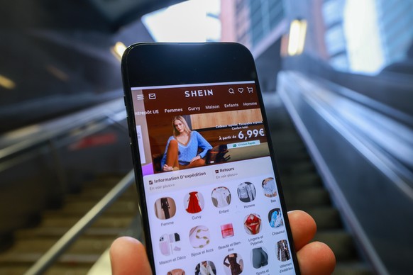 epa12749294 The Shein website is displayed on a smartphone in front of the European Commission headquarters in Brussels, Belgium, 17 February 2026. The European Commission is expected to provide a for ...
