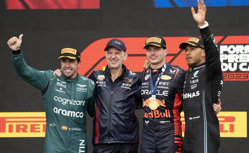 Winner Red Bull Racing&#039;s Max Verstappen, of the Netherlands, and his technical director, Adrain Newey, stand next to second place finisher Aston Martin driver Fernando Alonso, left, of Spain, and ...