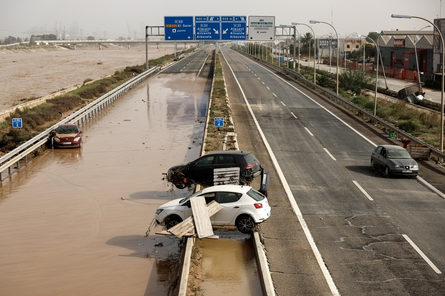 epa11692480 Damaged vehicles lie along a highway in the flood-hit city of Valencia, eastern Spain, 30 October 2024. The intense rainfall impacting the eastern part of the country resulted in more than ...
