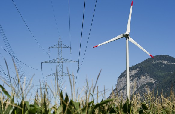 ARCHIV --- ZUR MELDUNG, DASS DER STROMMARKT AB 2018 VOLLSTAENDIG GEOEFFNET WERDEN SOLL, STELLEN WIR IHNEN FOLGENDES BILD ZUR VERFUEGUNG --- Eine Windkraftanlage neben Hochspannungsmasten, aufgenommen  ...