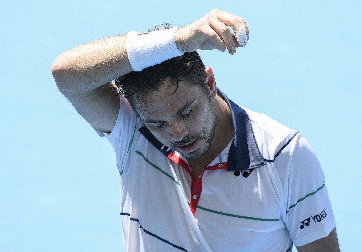 Switzerland's Stan Wawrinka wipes the sweat from his face during his match against Kazakhstan's Mikhail Kukushkin in a tuneup event ahead of the Australian Open tennis championships in Melbo ...
