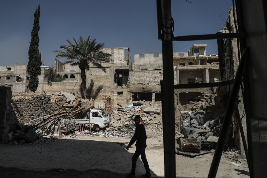 epa06604543 A man walks through heavily bombed Douma in eastern Ghouta, Syria 14 March 2018. Nearly ceaseless airstrikes for weeks by forces loyal to the Syrian government have left more than 1250 dea ...