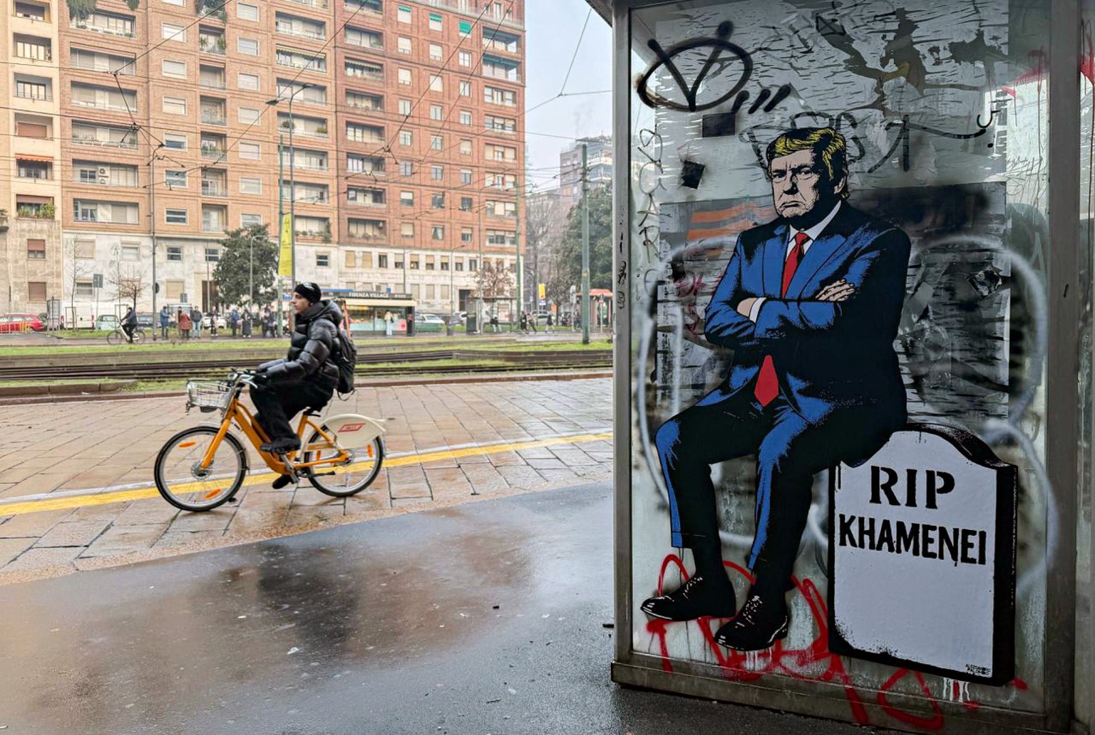 epaselect epa12653154 A new mural by Italian contemporary artist and activist aleXsandro Palombo showing US President Donald Trump sitting atop a tombstone with the slogan 'RIP Khamenei', th ...