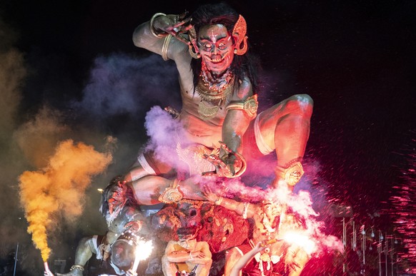 epa12830010 Balinese carry giant effigies depicting aspects of evil, known locally as 'Ogoh-ogoh', during a parade before Nyepi Day, the Balinese Day of Silence, which marks the Balinese Hin ...