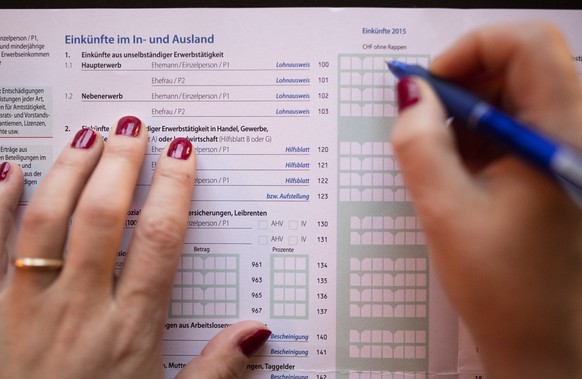 ARCHIVBILD ZUR ZUNAHME DER SELBSTANZEIGEN VON STEUERSUENDERN BEI DEN KANTONEN -- A married woman fills in details as to income made domestically and internationally in a Swiss tax return, photographed ...