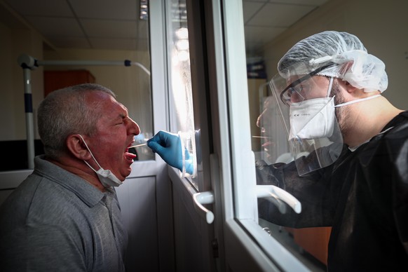 epa08437700 A man reacts while undergoing a swab test for COVID-19 at the Istanbul Sisli Hamidiye Etfal Training and Research Hospital, in Istanbul, Turkey, 20 May 2020 (issued 22 May 2020). President ...
