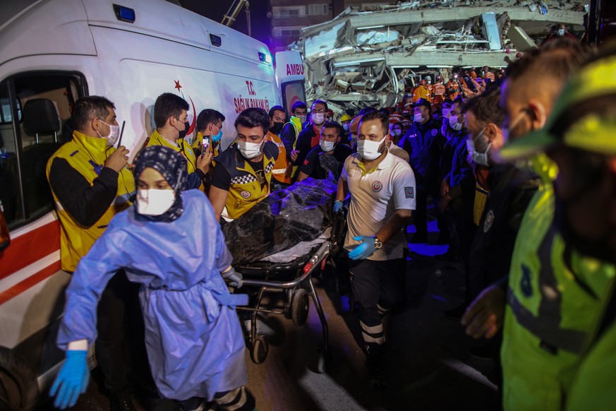 epa08787245 Rescue and health workers carry a dead body from a collapsed building after a 7.0 magnitude earthquake in the Aegean Sea, at Bayrakli district in Izmir, Turkey, 31 October 2020. According  ...