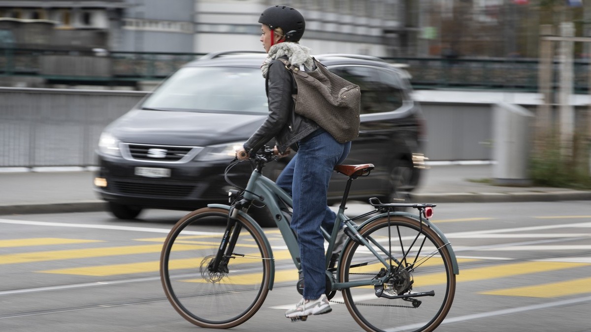 Eine E-Bike-Fahrerin mit Helm kreuzt das Limmatquai in Zuerich am 5. Oktober 2020. (KEYSTONE/Gaetan Bally)