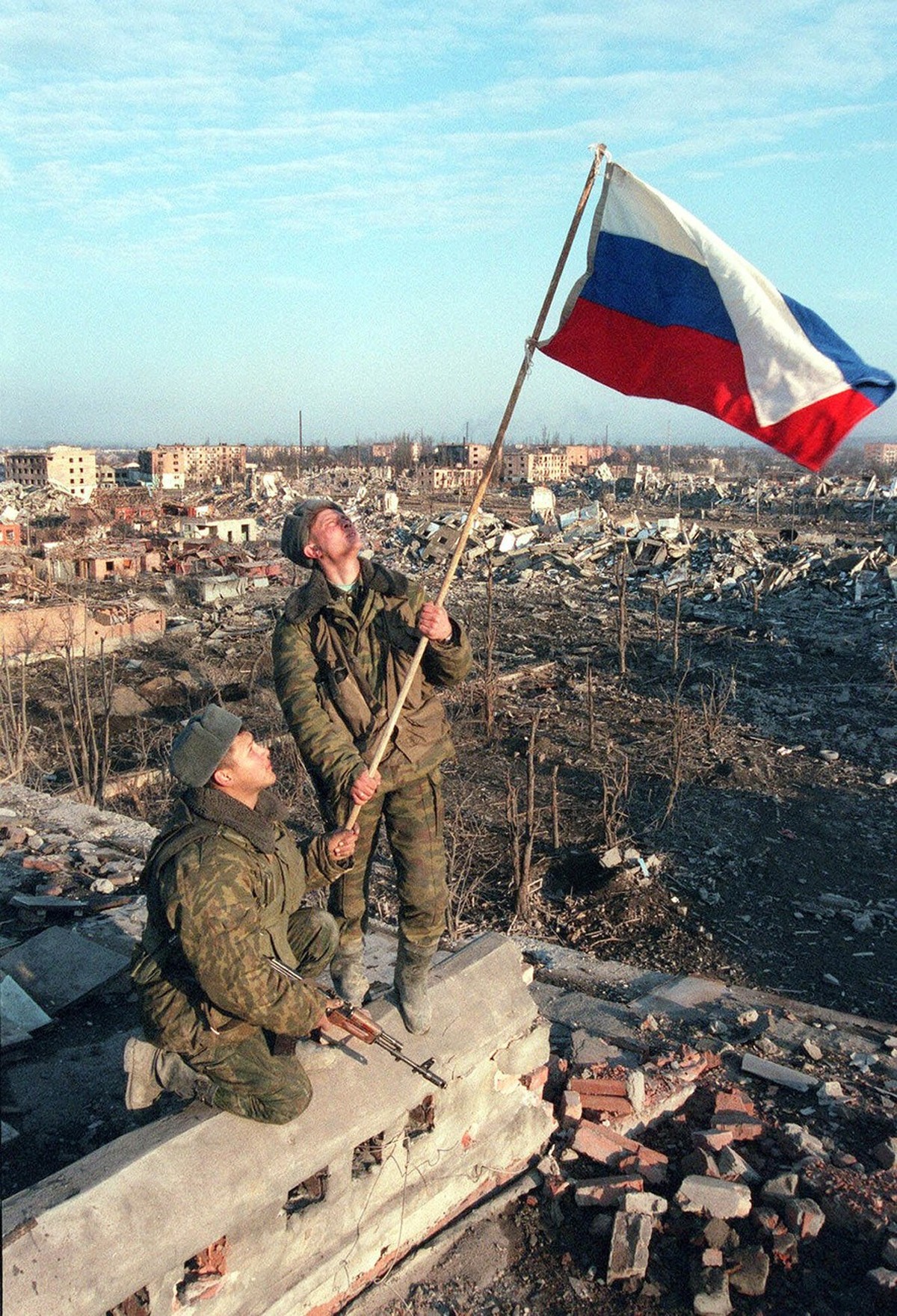 Russian soldiers install a Russian flag over ruins of an apartment building where they say a Chechen sniper was found and killed in Grozny, in this March 1, 2000 photo. Chechnya's parliament on W ...